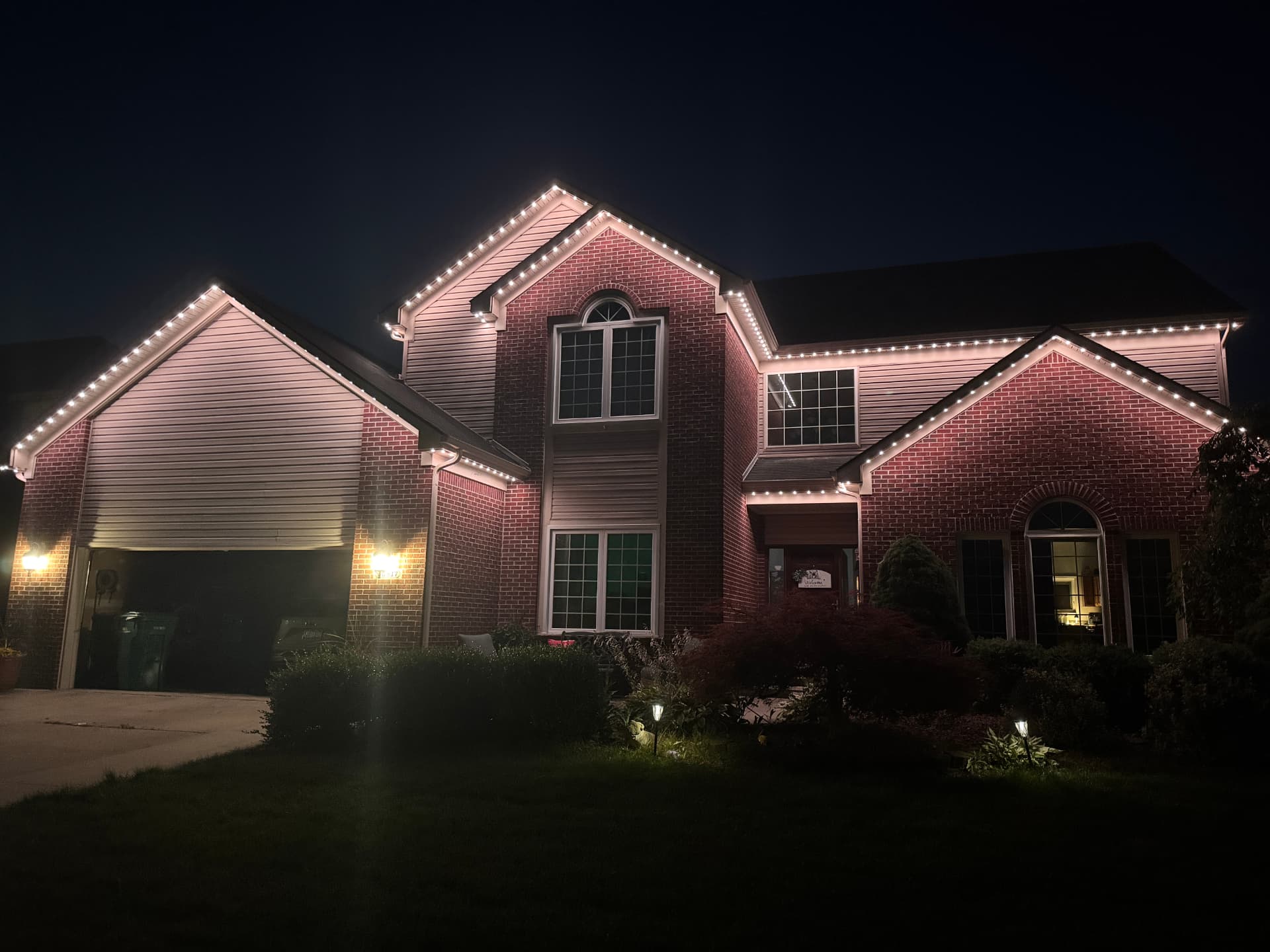 Brick home with warm white permanent LED roofline lighting