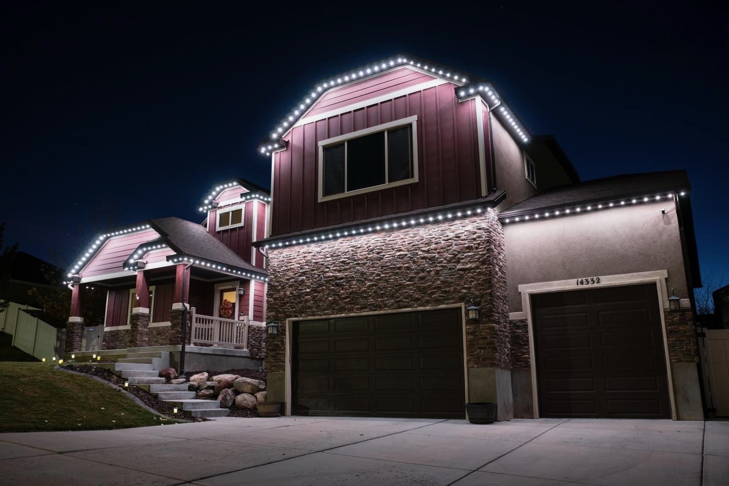 Two-story home outlined in bright white permanent LED roofline lighting
